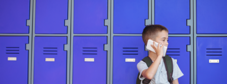 image of young student with cellphone by lockers